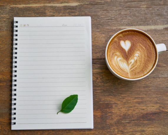 coffee cup & notebook with green leaf